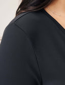 Close-up view of the Luxe Long Sleeve Bodysuit showcasing the sleek fabric and scoop neckline.