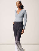 Model wearing Luxe Long Sleeve Bodysuit in gray with stylish black ombre pants.