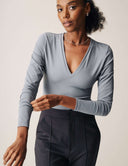 Luxe Long Sleeve Bodysuit in soft blue with flattering scoop neckline and fitted design, perfect for versatile styling.