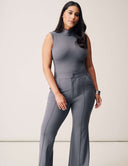 Model showcasing Luxe Sleeveless Bodysuit with sleek design and turtleneck in gray color, paired with stylish trousers.