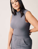 Model wearing Luxe Sleeveless Bodysuit in grey, featuring a turtleneck design and seamless fit.