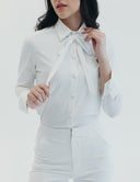 Elegant white buttoned blouse with neck bow, part of the Meet Me at Noon corporate suit collection.