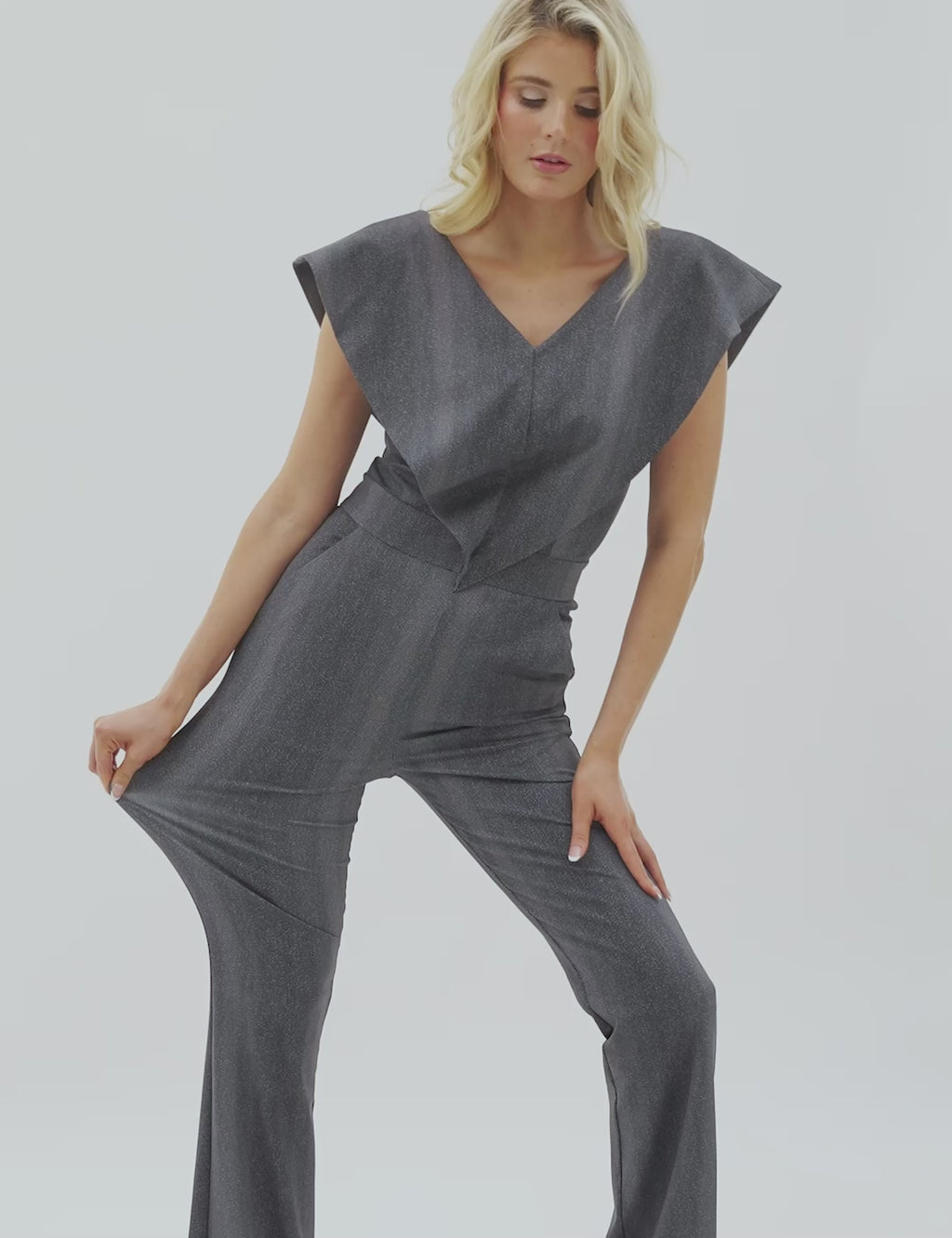 Model wearing the Supernova jumpsuit with v-neck and wide sleeves, showcasing the stretch of the fabric