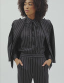 Model showcasing the Striped Night power suit with a double lined blazer and flared pants, perfect for any occasion.Model showcasing the Striped Night power suit with a double lined blazer and top, perfect for any occasion.