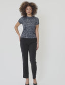 Model wearing Signature Luxe Tee in original lamé print paired with black pants, showcasing a stylish casual look.