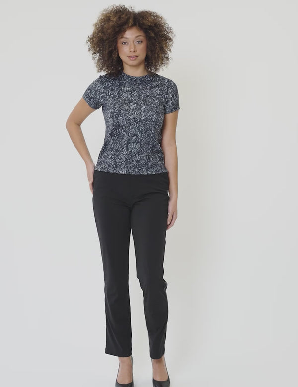 Model wearing Signature Luxe Tee in original lamé print paired with black pants, showcasing a stylish casual look.
