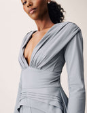 Model showcasing the Promise Me Nothing Top with deep V-neckline and elegant draping in soft gray.
