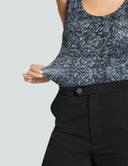 Woman showcasing the black diamond scoop neck tank bodysuit fabric with stylish black pants, highlighting comfort and style.