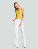 Model wearing a yellow scoop neck tank bodysuit with white flared pants for a stylish and comfortable look.